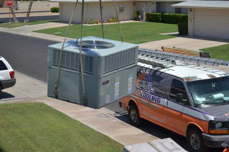 A large HVAC unit being lifted by a crane for installation or replacement by 1 800 Cooling, INC in Phoenix, AZ.