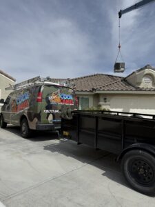 An HVAC unit being lifted by a crane over a residential house for installation by Cool Camel HVAC in Henderson, NV
