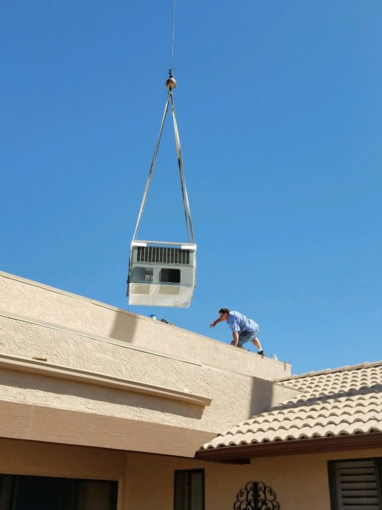 An HVAC unit being lifted by a crane onto a rooftop during installation by Advanced Comfort A/C & Heating in Phoenix, AZ.