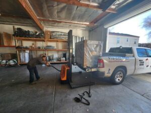 A Jaguar Heating & Air employee moving an HVAC unit with a pallet jack for delivery in Sacramento, CA