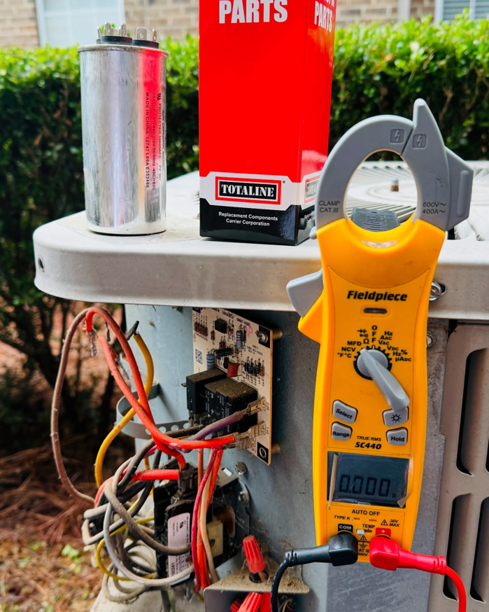 A clamp meter connected to an outdoor HVAC unit during a diagnostic check by Ortez Home Services LLC in Charlotte, NC.