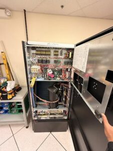 An open electrical panel and control board of an HVAC unit being serviced by Oakes AC Services, LLC in Louisburg, NC