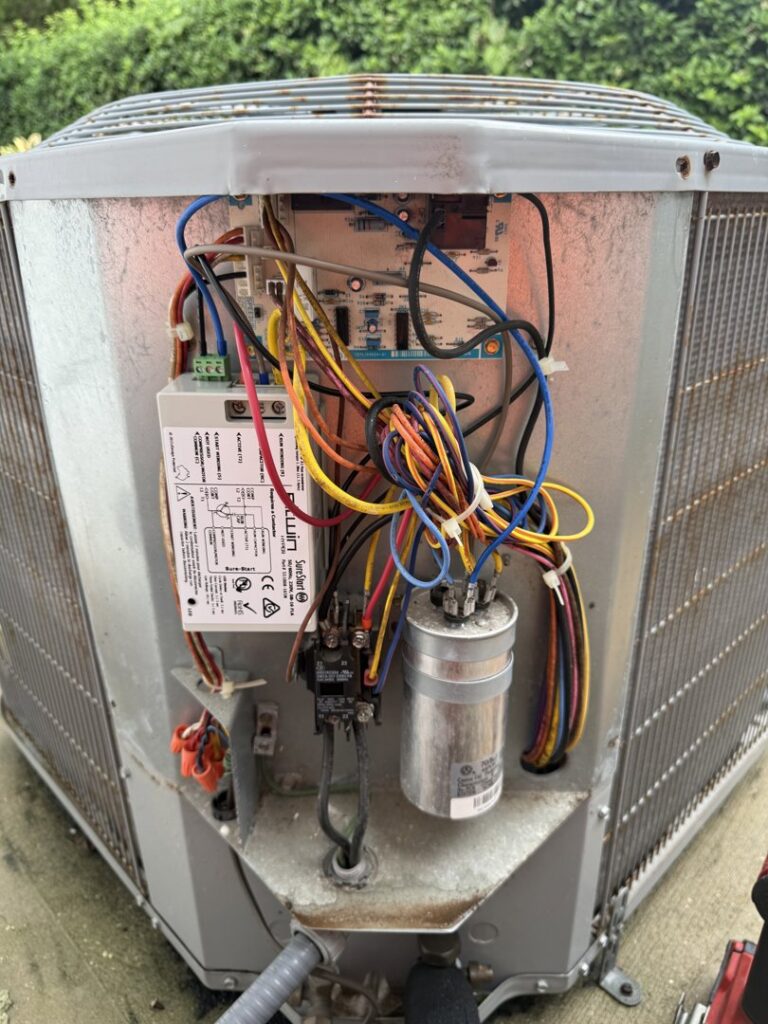 Close-up of electrical wiring inside an outdoor HVAC unit being serviced by Tenax Electrical Company in Jacksonville, FL.