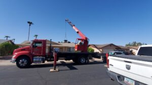 An HVAC unit being hoisted by a crane onto a residential roof for installation by Ash Cooling & Heating in Mesa, AZ.