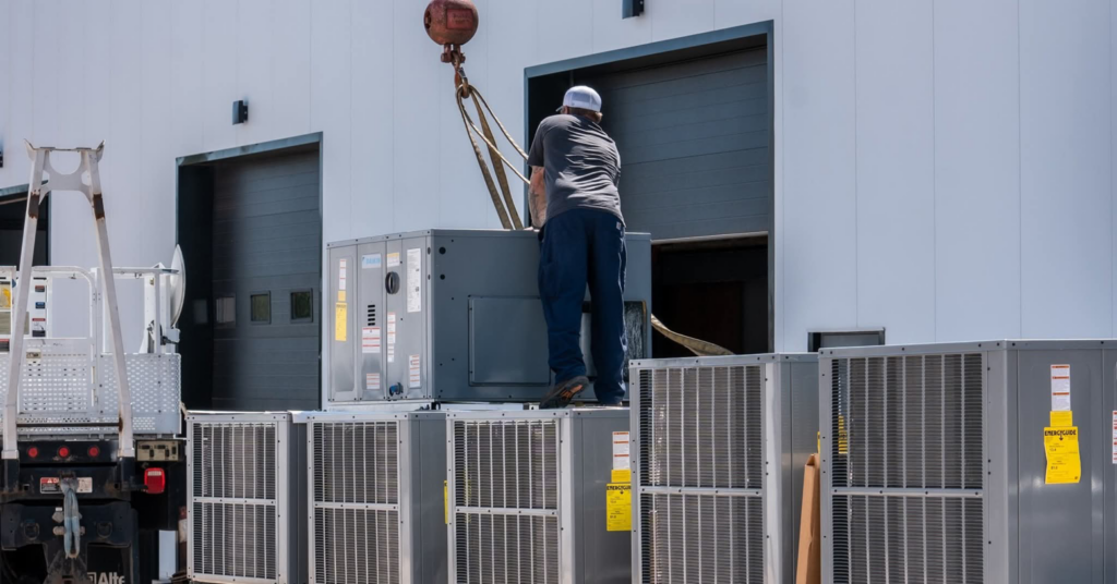 A technician installing a new HVAC outdoor unit with a crane for On the Mark Heat & Air OKC in Oklahoma City, OK