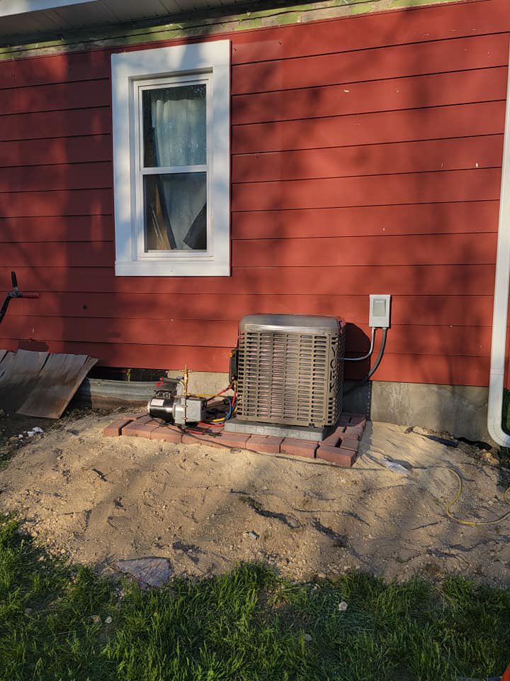 An outdoor HVAC unit being installed or repaired next to a house by Proambient Mechanical in Elgin, IL