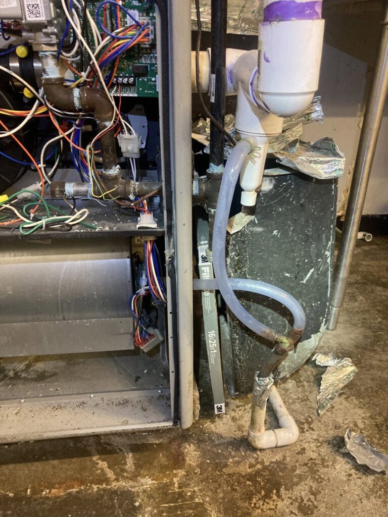 Close-up of internal wiring and components of an HVAC unit, showing repair work by Manny Services in Syracuse, NY.