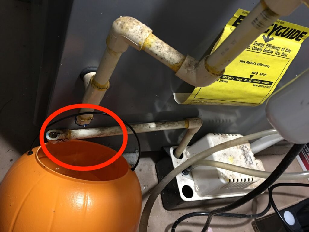 An HVAC unit with a leaking condensate drain line, indicating a repair job by Earth Core Energy Services in Waterbury, CT.