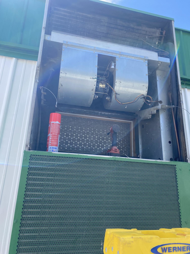 An HVAC technician performing maintenance inside an air handler unit for Fox Heating and Air service in Hueytown, AL.