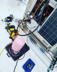 Outdoor HVAC unit undergoing maintenance with pressure gauges and tools by GreenFlow Heating & Cooling in Tacoma, WA