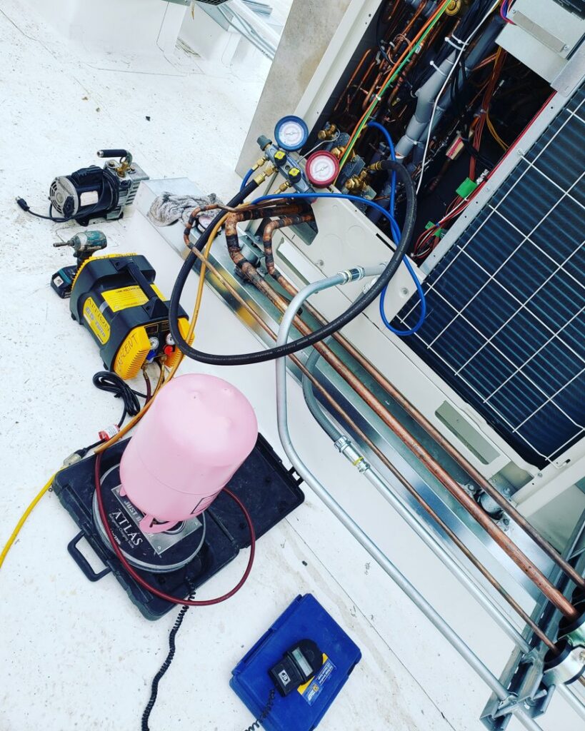 Outdoor HVAC unit undergoing maintenance with pressure gauges and tools by GreenFlow Heating & Cooling in Tacoma, WA