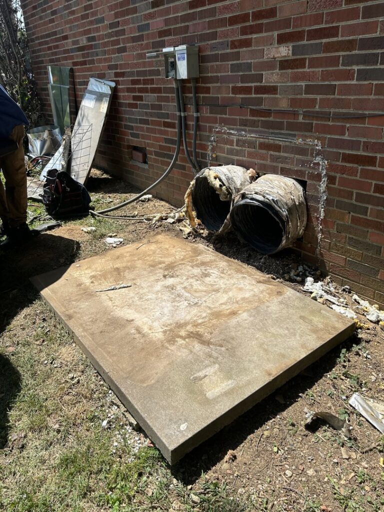 An old concrete pad and exposed ductwork during HVAC unit removal or preparation by Comfort Zone Mechanical in Antioch, TN.