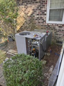 An outdoor HVAC unit undergoing repair or maintenance by Elite Air and Heat of Summerville, SC.