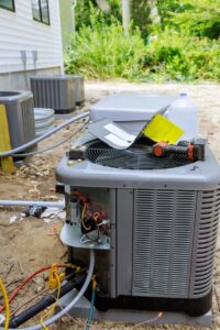 An outdoor HVAC unit undergoing repair or maintenance with tools and wiring visible by Ault's Cooling HVAC Services LLC in Chandler, AZ.