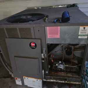 An outdoor Rheem HVAC unit undergoing repair or service by Christie Brothers Heat and Air, LLC in Summerville, SC.