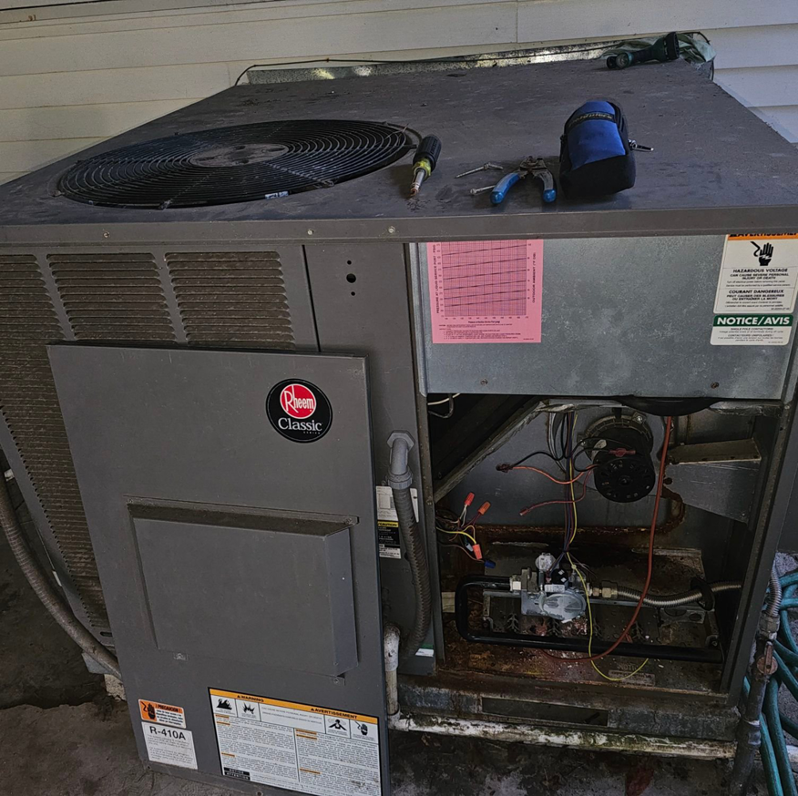 An outdoor Rheem HVAC unit undergoing repair or service by Christie Brothers Heat and Air, LLC in Summerville, SC.