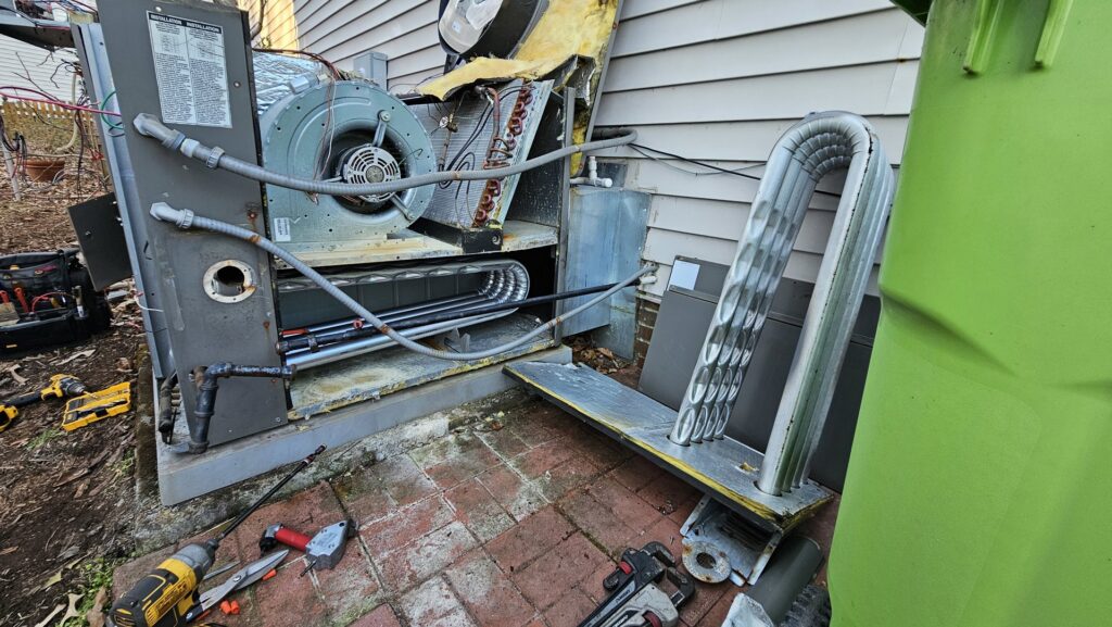An open outdoor HVAC unit showing internal components during repair or service by Peak Seasons HVAC in Raleigh, NC.