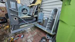 An open outdoor HVAC unit showing internal components during repair or service by Peak Seasons HVAC in Raleigh, NC.