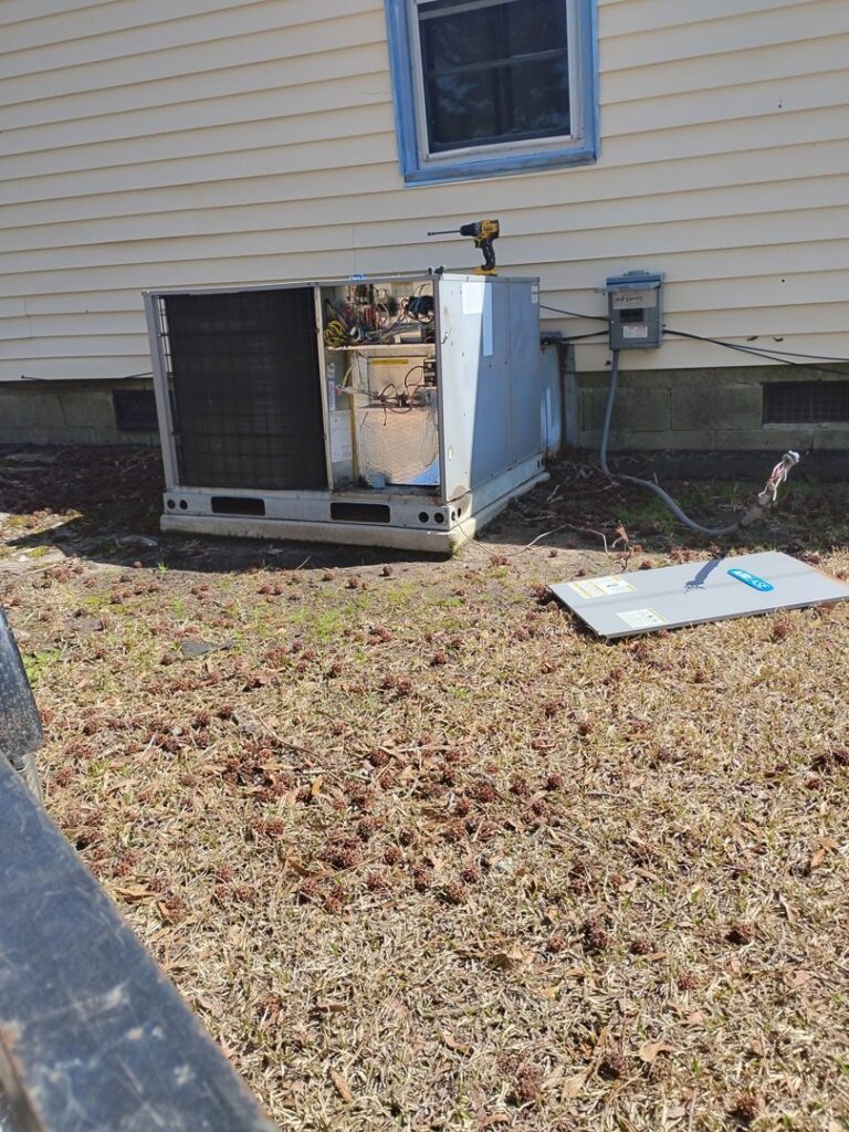 An outdoor HVAC unit with its panel removed for repair or service by Miller's Home Comfort-Chesapeake in Chesapeake, VA.