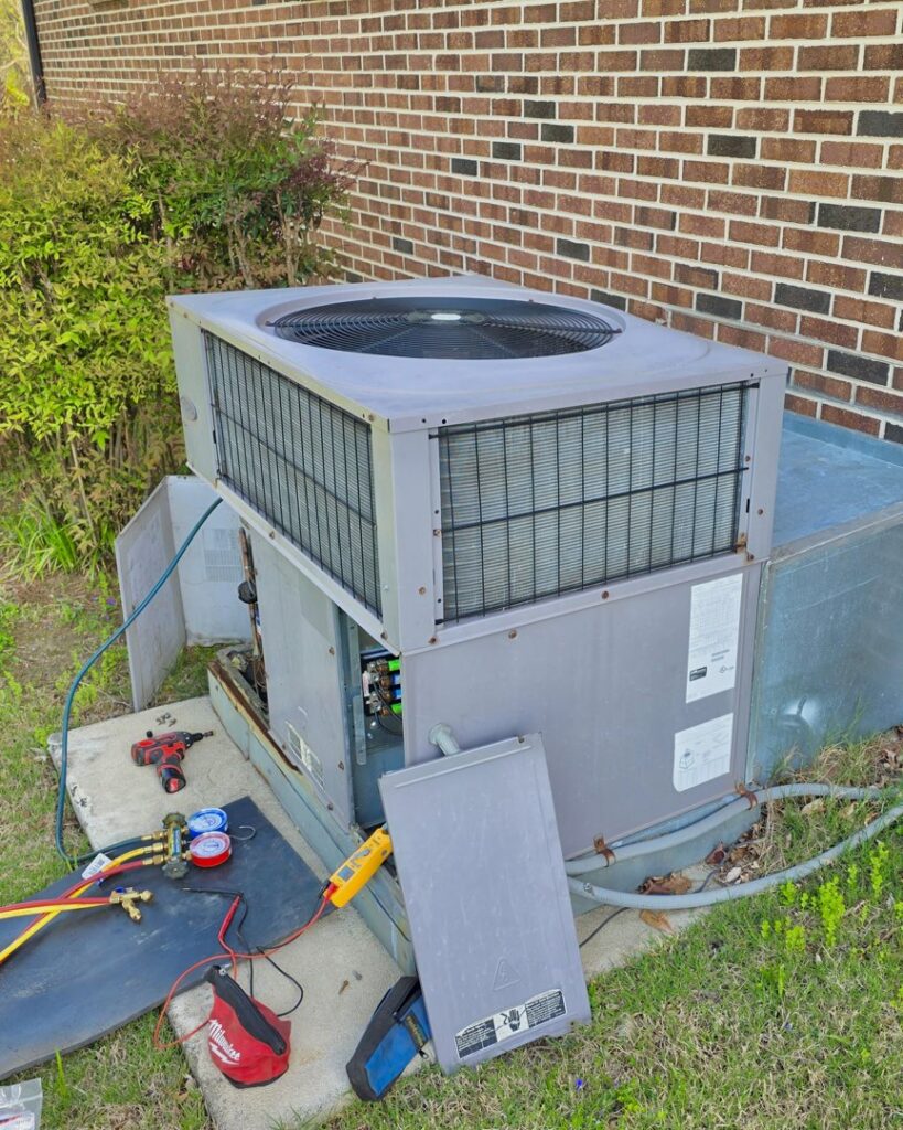 An outdoor HVAC unit undergoing repair with various tools laid out by Bruce Heating & Air in Kennewick, WA.