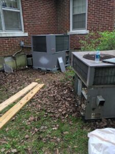An old HVAC unit being replaced by a new one, showing the process of unit replacement by West Tennessee Heat & Air in Memphis, TN
