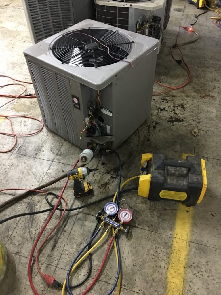 An HVAC technician servicing or installing an outdoor air conditioning unit with tools at Parks Heating Cooling Plumbing & Electrical in Indian Trail, NC