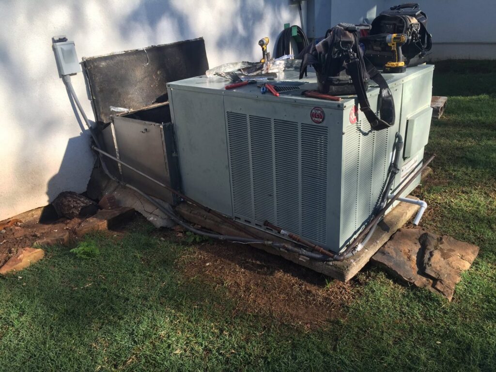 An older outdoor HVAC unit undergoing service or replacement by Prudhom Mechanical LLC in Edmond, OK