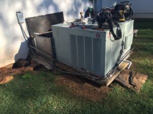 An older outdoor HVAC unit undergoing service or replacement by Prudhom Mechanical LLC in Edmond, OK