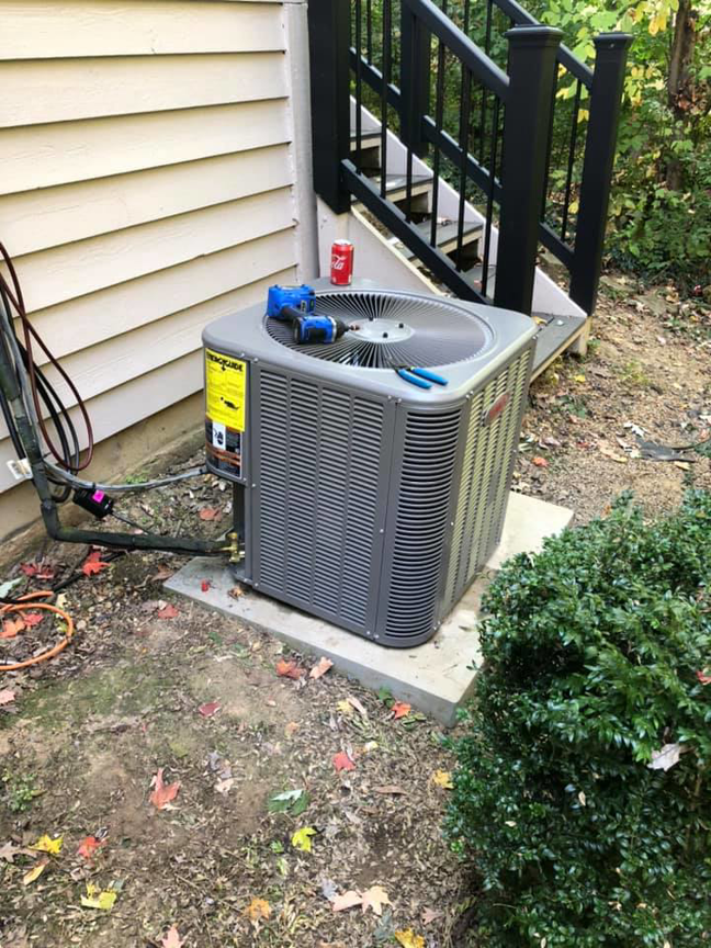 An outdoor HVAC unit with tools on top, indicating service or repair work by L.N.P Heating & Cooling in Columbus, OH