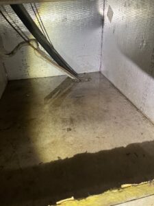 Water pooling inside an HVAC unit, indicating a leak or drainage issue, for Cooler Solutions LLC Heating & Air in Gulfport, MS.