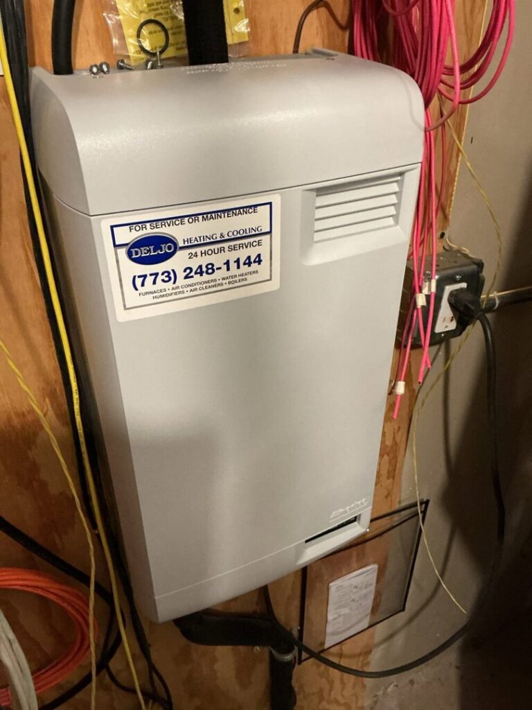 An indoor HVAC unit with a Deljo Heating, Cooling & Plumbing service sticker, indicating maintenance or installation in Chicago, IL.