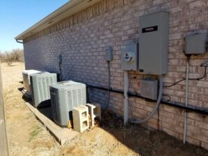 Exterior of a building showing HVAC units, an electrical meter, and a Generac generator installed by Warner Electric Service, LLC in Broken Arrow, OK.