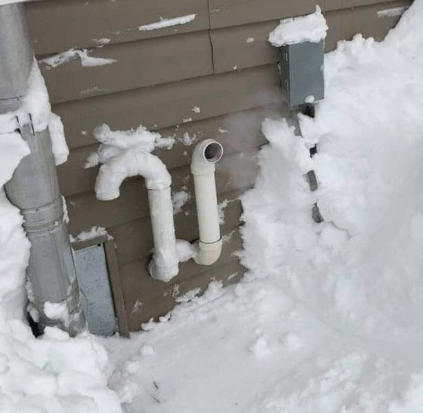 HVAC vent pipes on the side of a house covered in snow by Extreme Heating & Cooling in Beaver Dam, KY