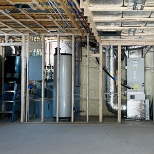 A utility room showing new HVAC ductwork, water heater, and boiler installation during construction by HVAC Fellows in Boston, MA.