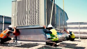 HVAC workers installing a large rooftop unit, demonstrating the services of Energy Logix in Austin, TX.