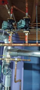 Circulator pumps and copper piping for a hydronic heating system installed by Evergreen Services in Warwick, RI.