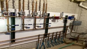A complex hydronic heating manifold system with copper pipes and valves installed by Terry Allen Plumbing & Heating in Flint, MI.