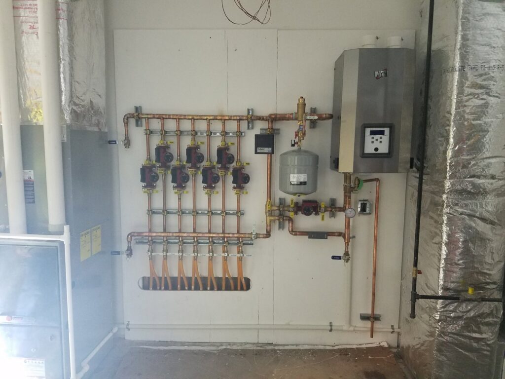A hydronic heating system with copper piping and pumps installed by Advantage Mechanical, Inc. in Appleton, WI.