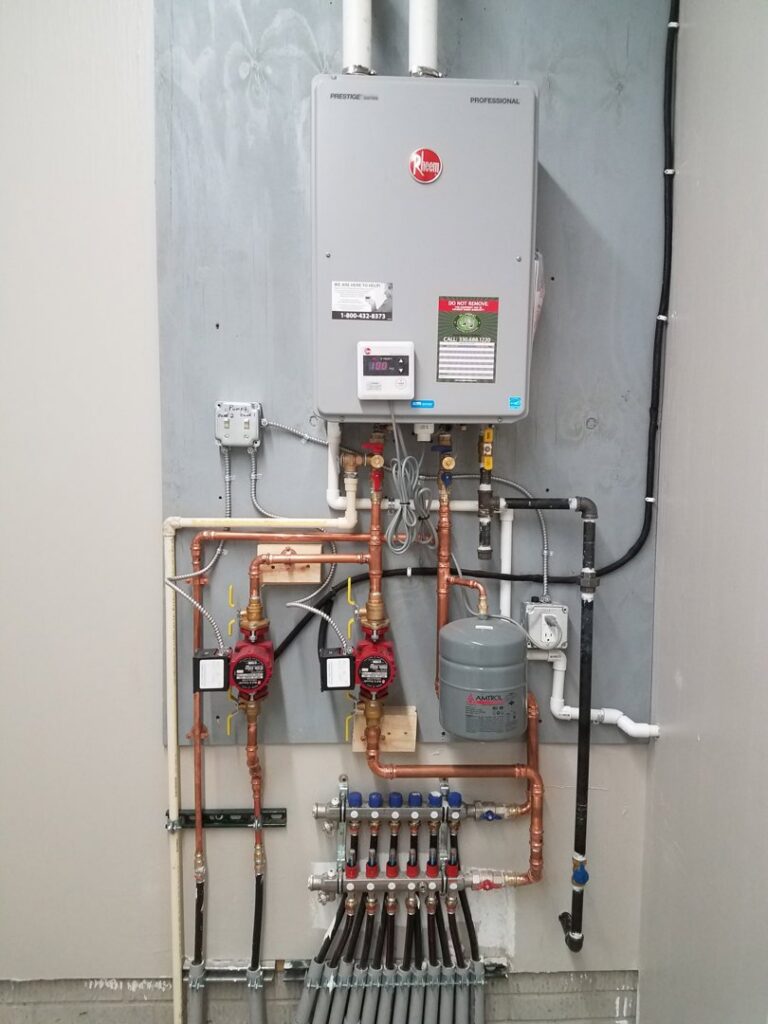 A complex hydronic heating system with a tankless water heater and manifold installed by Ash Plumbing, Drain & Sewer in Akron, OH.