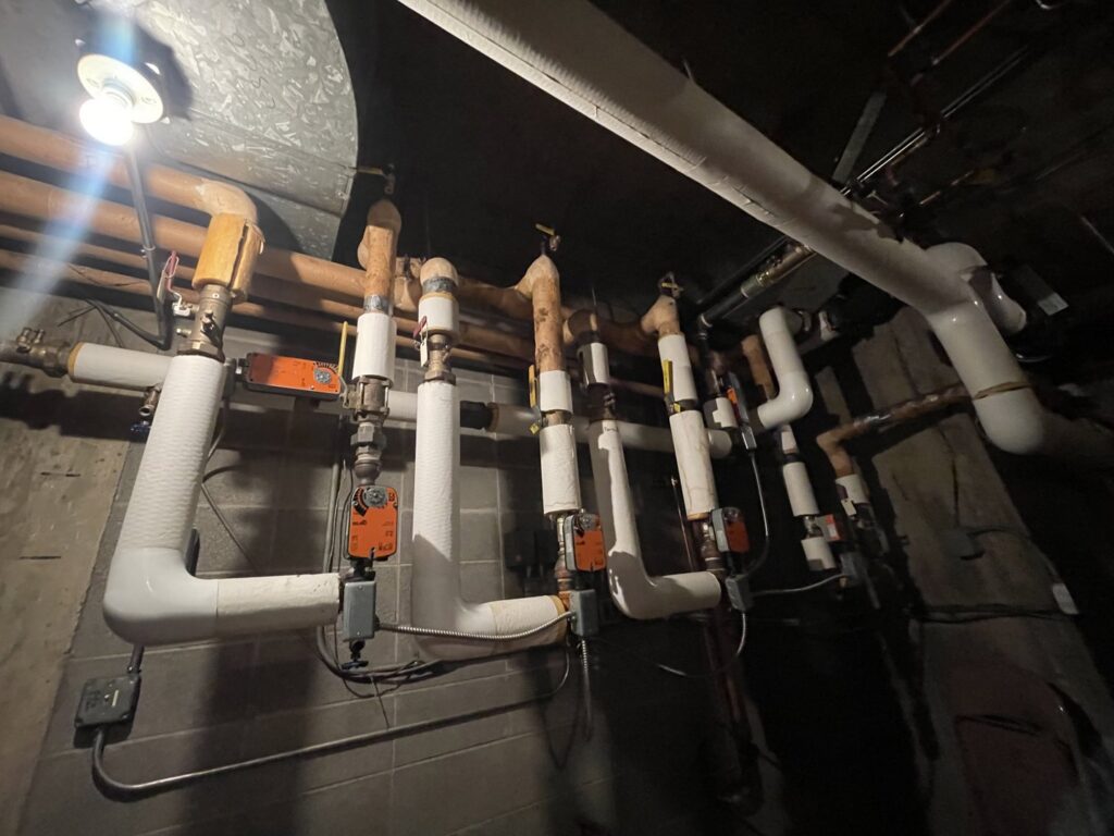 Insulated pipes and valves of a hydronic heating system, serviced by CHAMPS Heating&Air in Denver, CO