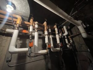 Insulated pipes and valves of a hydronic heating system, serviced by CHAMPS Heating&Air in Denver, CO