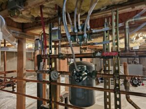 Intricate copper piping, valves, and pumps of a hydronic heating system installed by Perfect Temp LLC in Bozeman, MT.