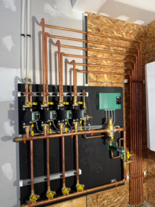 Detailed view of copper piping and pumps for a hydronic heating system by Boudreau's Heating in Vassalboro, ME.