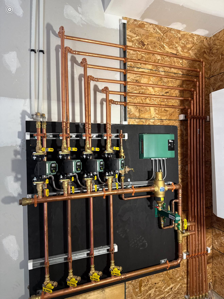 Detailed view of copper piping and pumps for a hydronic heating system by Boudreau's Heating in Vassalboro, ME.
