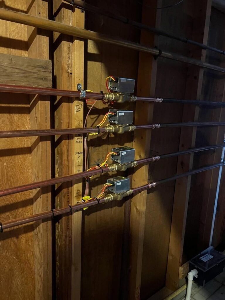A hydronic heating or zone control system with copper pipes and valves installed by Neal Harris Service Experts in Overland Park, KS.