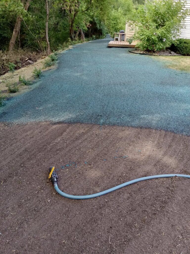 A large area of ground prepared for a new lawn with hydroseeding, showing a hose for watering, by Nice Grass Minnesota LLC in Minneapolis, MN.
