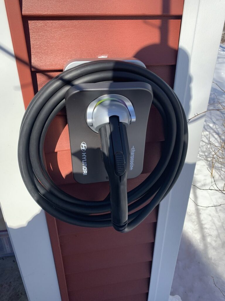 A Hyundai EV charging station professionally installed on a home's exterior by Building Connections LLC in Auburn, ME.