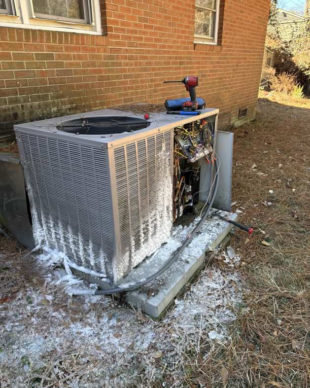 An iced-over outdoor HVAC unit requiring repair, serviced by Southern Comfort Heating/Cooling/Gas in Fayetteville, NC.