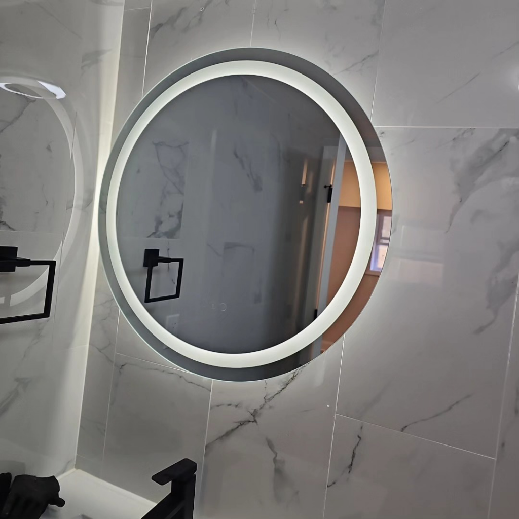A modern illuminated round bathroom mirror installed by C&J And Sons Multi Services in Newark, NJ.
