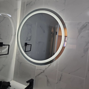 A modern illuminated round bathroom mirror installed by C&J And Sons Multi Services in Newark, NJ.